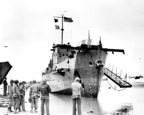 USS LCI(L)-93 aground on Omaha Beach. She still flies her flag, though knocked out of the invasion ripped and wounded on the beach. 